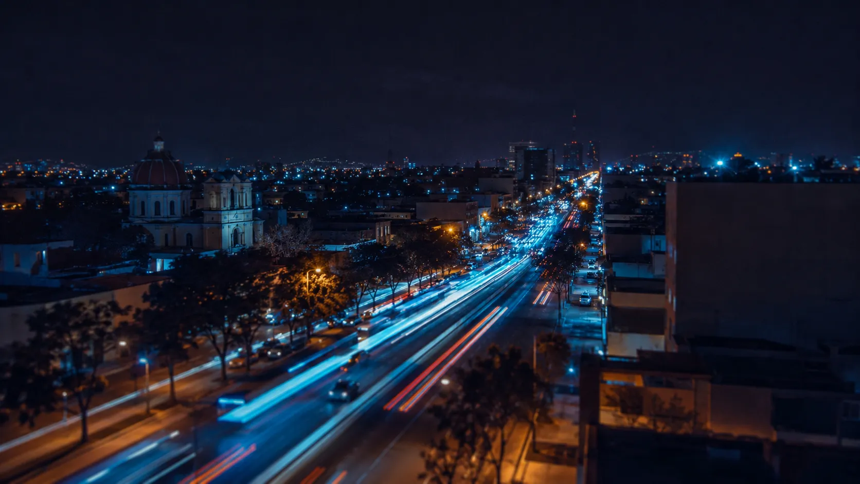 Mexican city avenue at night with bus light trails