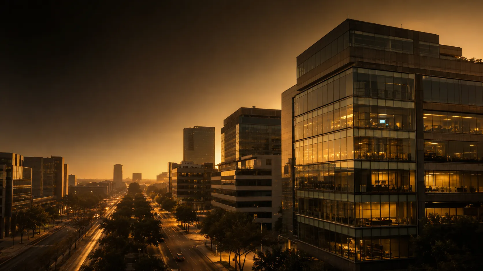Modern business district at golden hour with backlit glass offices and screens glowing behind the facades